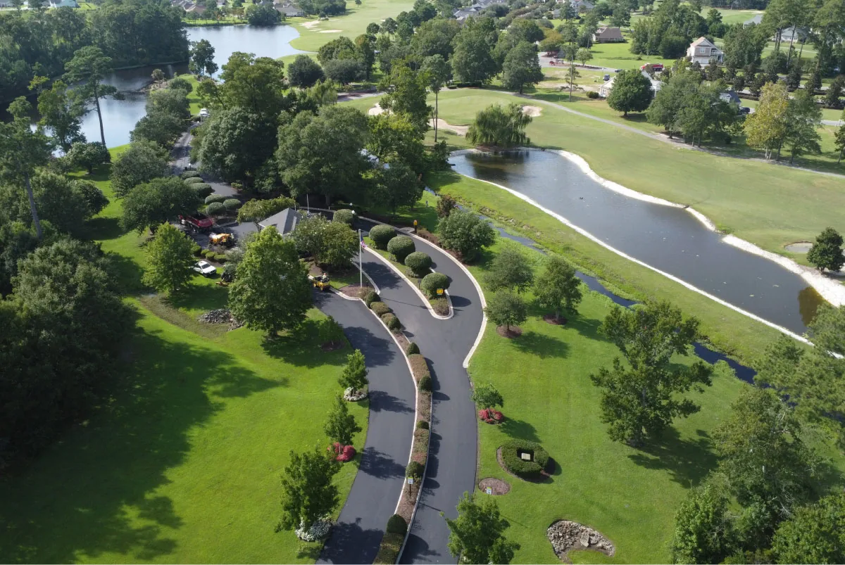 aerial view of a street, lakes, and green grass & trees