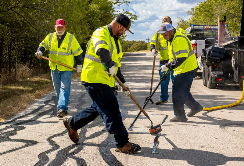 pave america empoyees sealing cracks in the pavement