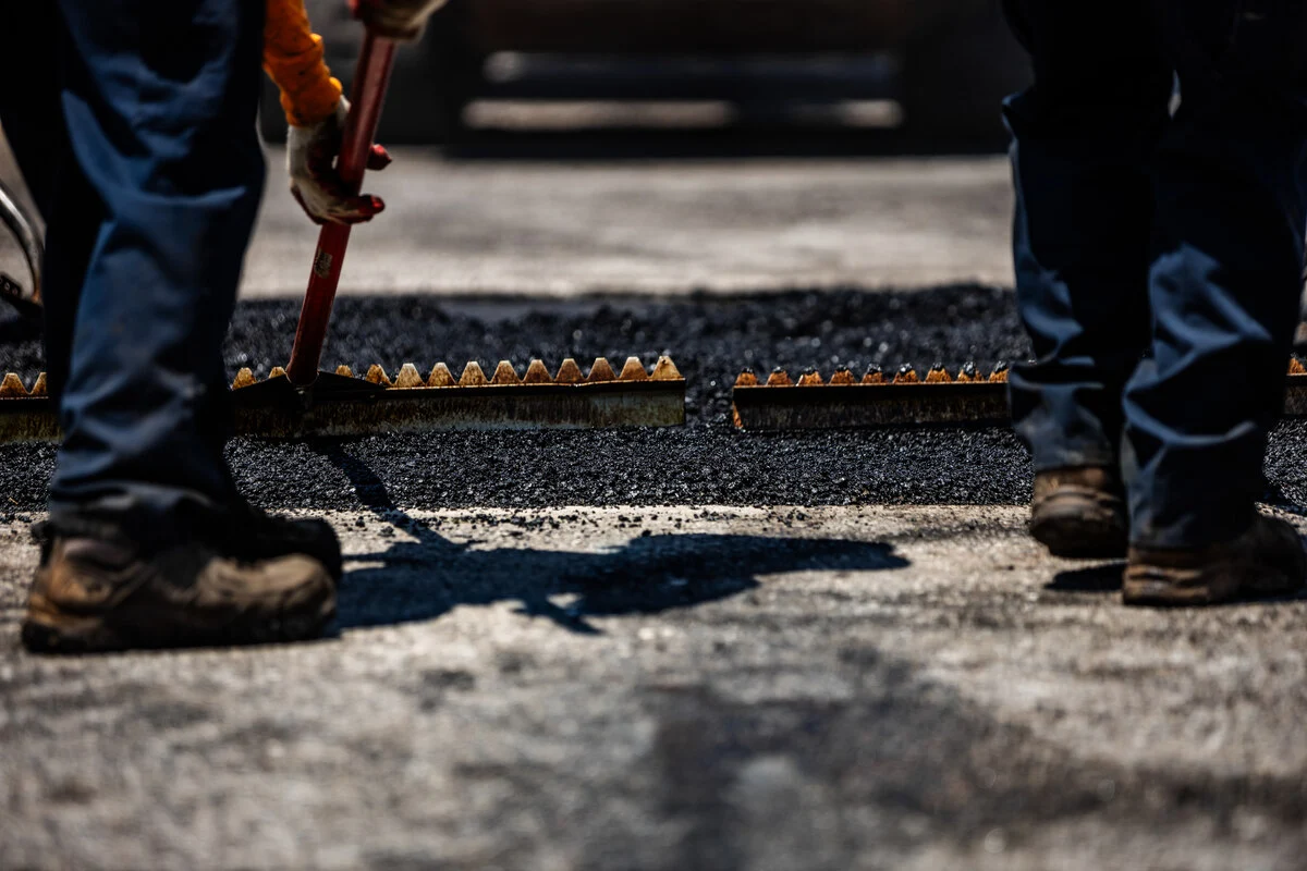 pave america employees raking asphalt
