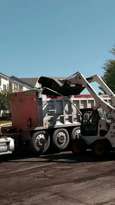 pouring asphalt millings into a dump truck